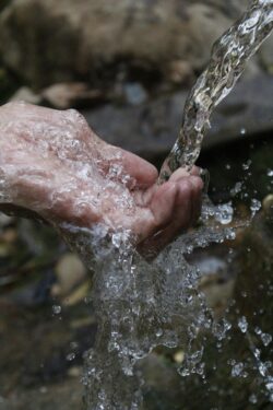 Clean Drinking Water Running over Human Hand