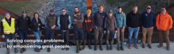 Drone photo of EnviroScience Ecological Restoration Services team standing on a bridge over a stream, wearing field gear and safety vests, showcasing teamwork and fieldwork culture.