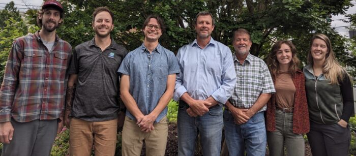 EnviroScience Hendersonville, NC staff team group photo outdoors, featuring biologists, environmental scientists, and project managers standing in front of trees during summer field season.