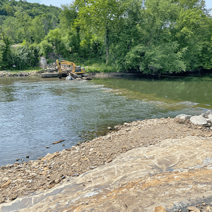 Excavator removes dam material from the Mahoning River in Lowellville, Ohio, during river restoration work.