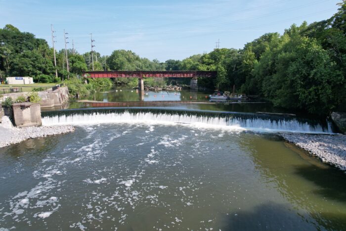 Low-head dam on the Mahoning River at Summit Street in Warren, Ohio, prior to full removal, with water flowing over the dam crest.