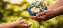 Hands holding a small globe of Earth and passing it to an outstretched child’s hands, symbolizing shared responsibility for protecting the planet.