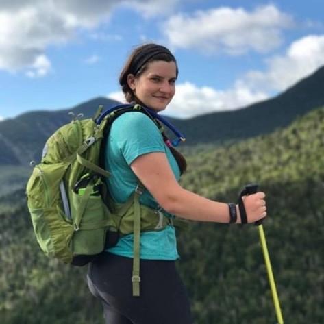 Laura Muzal, EnviroScience Marine Senior Project Manager and Technical Writer, hiking with field gear in a mountainous landscape.